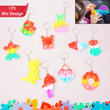 A child's hand actively pressing the bubbles on a compact Pop It Keychain.