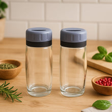 Close-up of transparent acrylic salt and pepper shakers with flip-top lids by Apex