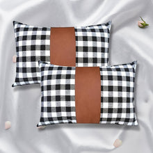 A pair of stylish leather and cotton cushion covers displayed on a modern sofa.