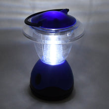 The blue and clear plastic lantern is brightly illuminated, casting a glow on the surrounding gray surface.