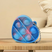Several mini fidget keychains in various shapes and colors, demonstrating their compact size and portability.