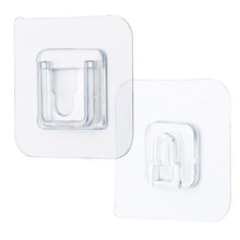 Single clear adhesive hook securely mounted on a smooth wall surface.