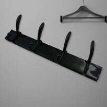 Top-down view of the 4-hook wall mount coat hanger holding various coats and hats.