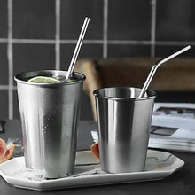 A sleek stainless steel straw elegantly placed next to a refreshing beverage.