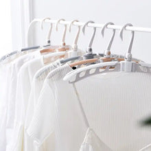 Adjustable arms of the folding clothes hanger demonstrated.