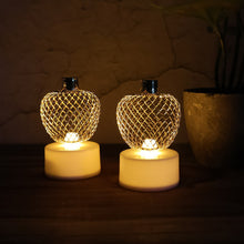 Three apple LED tealight candles creating a warm, ambient glow in a room.