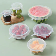 Set of 6 reusable silicone food covers on kitchen table