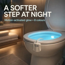Toilet with a blue glowing bowl from the motion sensor light, in a softly lit bathroom setting with towels.