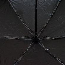 A DrizzlePro portable umbrella closed and ready to be stored, highlighting its compact design.