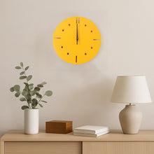 A yellow round wall clock hangs above a wooden console table with a plant, a wooden box, and a lamp.