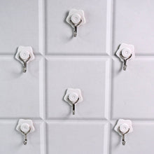 A yellow self-adhesive hook securely holding a towel in a modern bathroom.