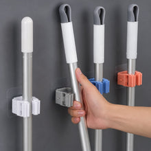Laundry room with wall-mounted broom holder for cleaning supplies