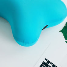 Two blue microbead pillows, one bone-shaped and one cylindrical, above a woman sleeping with a blue pillow.
