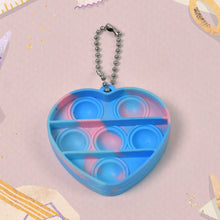 A hand holding a mini fidget keychain, highlighting its small size and easy grip for on-the-go stress relief.