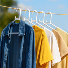 White plastic clothes hanger in practical use inside a closet