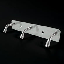 Stainless steel coat hook rack holding towels and bags
