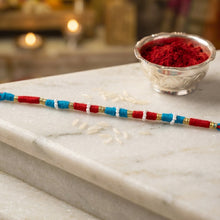 Decorative red rakhi thread bracelet with gold accents