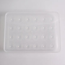 Clear plastic egg container next to traditional egg carton for size comparison