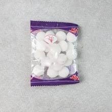 Close-up image of round naphthalene mothball tablets for wardrobe freshness