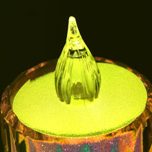 A close-up view of a single lit LED tea light, showing its textured clear body and bright yellow flame.