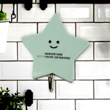 A set of strong self-adhesive hooks displayed neatly on a tiled kitchen wall, ready for use.