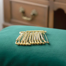 Boxed 12-piece set of elegant golden safety pin brooches
