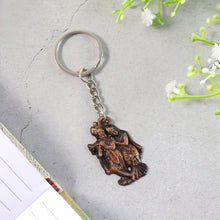 Close-up of Radha Krishna metal keychain showing detailed craftsmanship