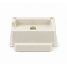 A cream plastic phone stand with two small holes and a larger central opening is shown from the front.