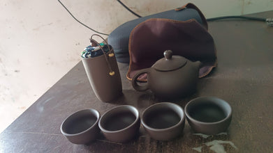 Tea set with teapot, cups & accessories on a wooden tray for travel or home