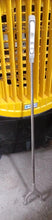 The garbage picker tool shown in use, making rubbish pickup effortless.