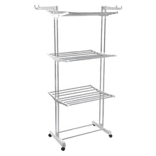 The 3-tier stainless steel drying rack with wheels, fully loaded with laundry.