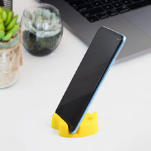 Desk setup featuring apple-shaped mobile stand with pen holder showing colorful pens