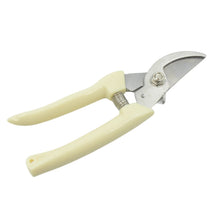 Pruning shears effortlessly cutting a small branch in a garden.