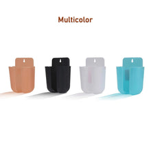 Wall organizer box holding a remote control and a mobile phone.