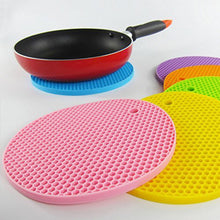 A red silicone hot pot mat being rinsed under water, illustrating its easy-clean feature.