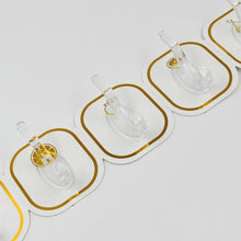 Transparent adhesive hooks installed on a white wall, blending seamlessly with home decor.