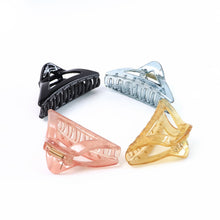 Assorted color triangle plastic hair claw clips laid out for selection