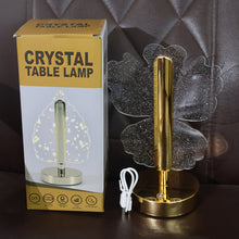 A crystal butterfly-shaped table lamp and its product box, with a white USB cable, on a brown surface.