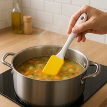 Assorted silicone spatulas and pastry brushes arranged in a modern kitchen setting.