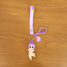 Detailed close-up of doll and cupcake charms on colorful rainbow strap keychain