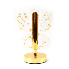 The golden butterfly lamp with clear wings and gold flakes, unlit, against a white background.