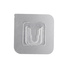 Transparent self-adhesive wall hook ready for easy peel-and-stick application.