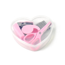 A clear heart-shaped container holding a pink stapler, tape dispenser, scissors, and staples on a white background.