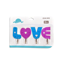 Multiple love shape self adhesive hooks organized on a kitchen wall.