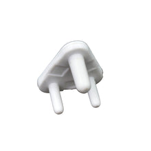 A child's hand reaching towards a covered electrical socket, demonstrating the protection of baby socket covers.