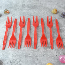 Stacked red disposable forks showing compact, portable design