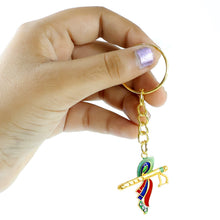 Krishna flute keychain resting on a wooden surface showing its metal finish
