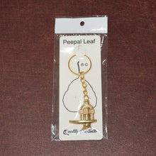 Different angle view of the golden Shivling metal keychain showcasing design