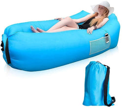 An adult relaxing on the Trekola inflatable camping lounger at a campsite.