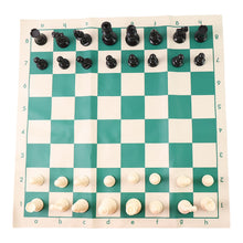 Plastic chess set pieces arranged on the roll-up green and white chess board